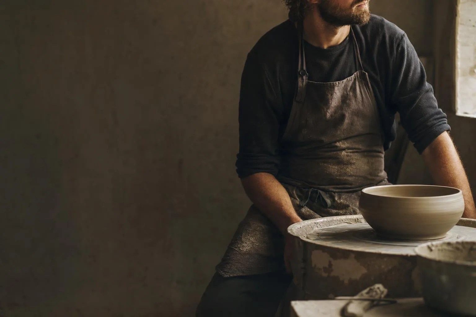 Potter's hands shaping a bowl on a spinning wheel